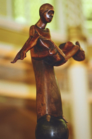 wooden figure holding body of another figure