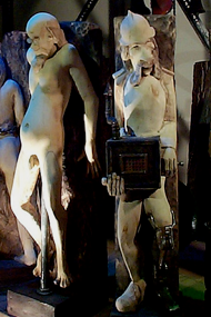 carved figures of naked man and organ grinder